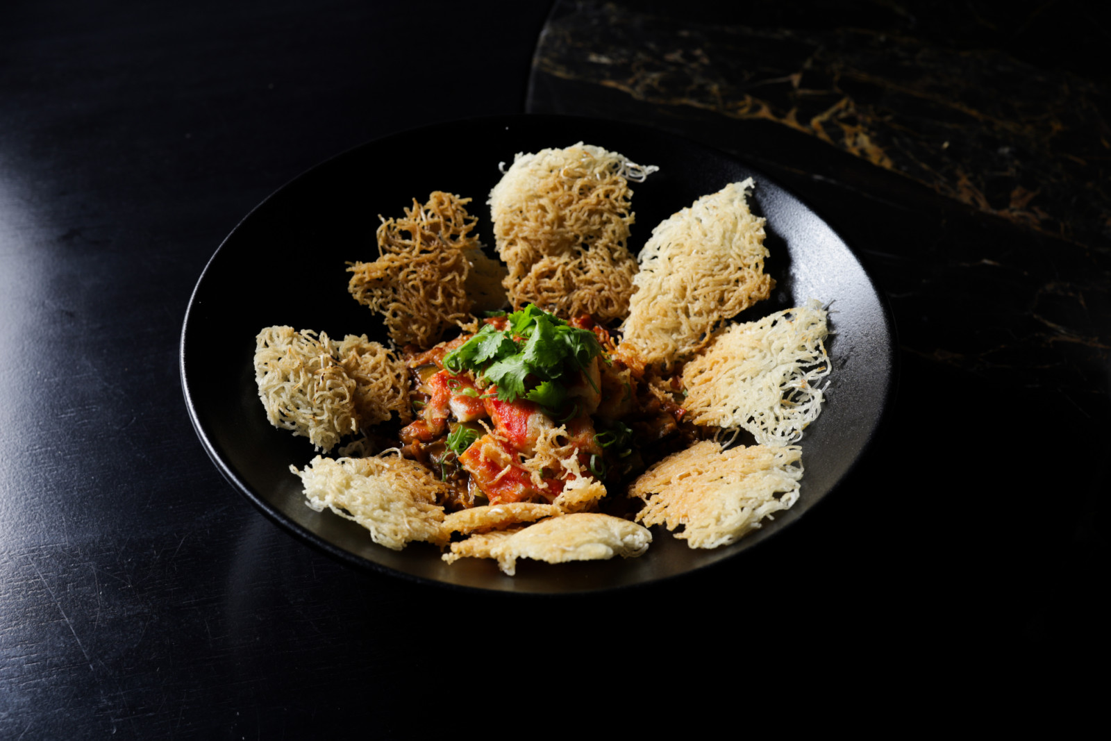 Crab meat, eggplant, chili sauce and crispy rice noodles at Mott 32 Cebu