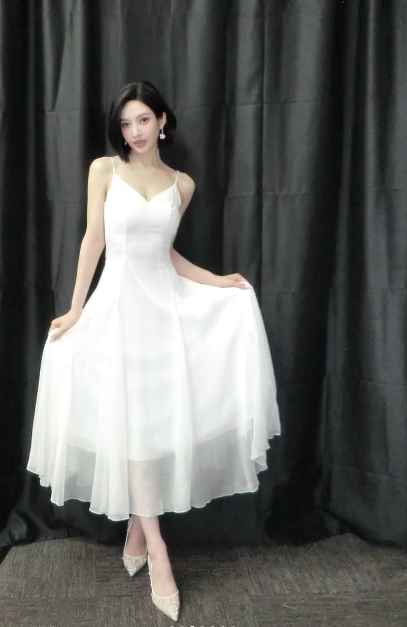 Joy of Red Velvet embodies effortless elegance in a pristine white dress and glittering heels, a true delight.