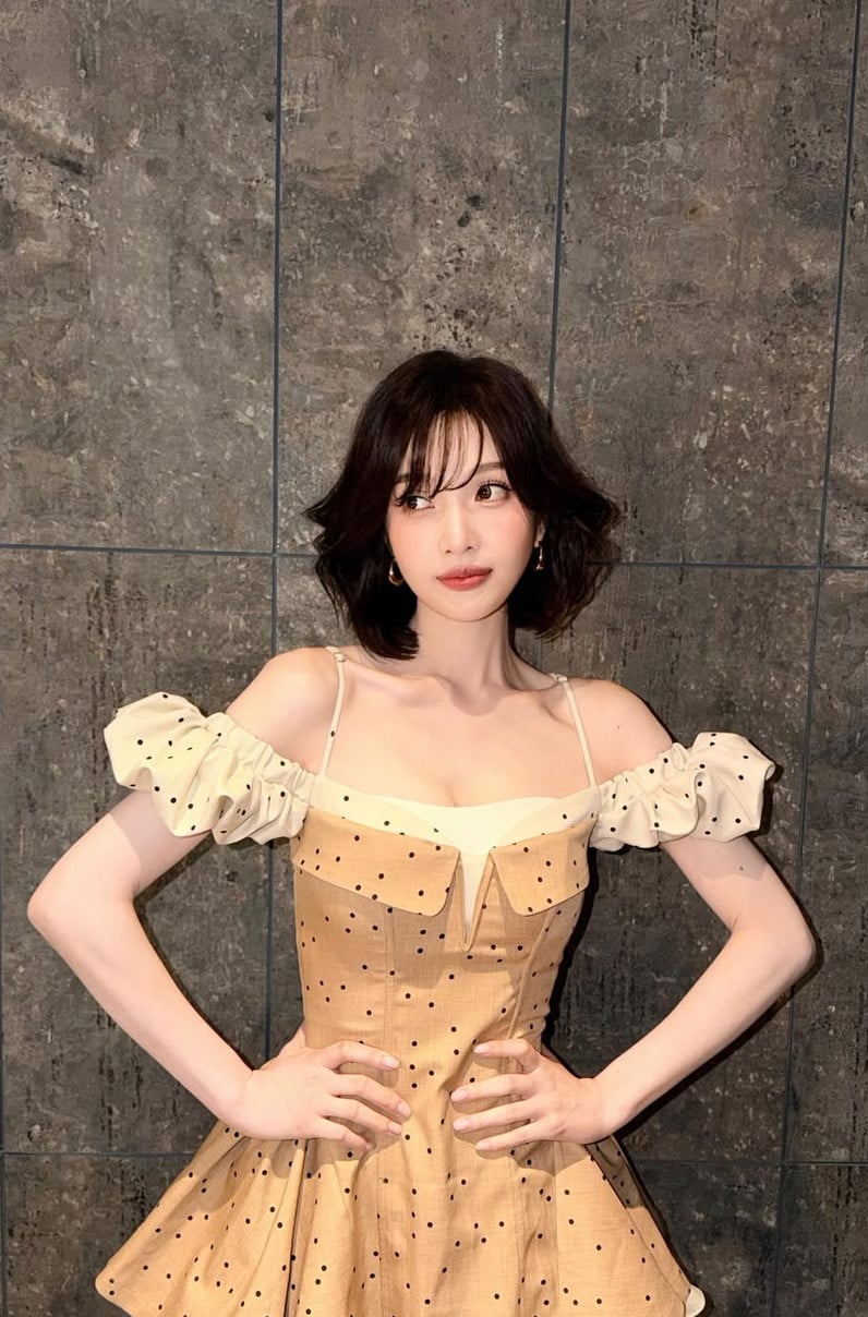 A woman wears a chic polka-dot off-the-shoulder dress.