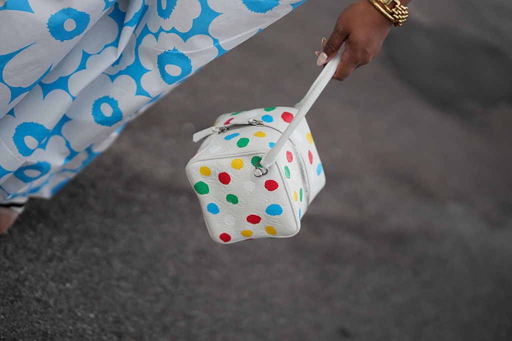 COPENHAGEN, DENMARK - AUGUST 6: A guest is seen wearing a white Louis Vuitton x Yayoi Kusama Square bag with multicolored polka dots during Day Four of Copenhagen Fashion Week Spring/Summer 2027, outside the Iamisigo show on August 6, 2026 in Copenhagen, Denmark. (Photo by Moritz Scholz/Getty Images)