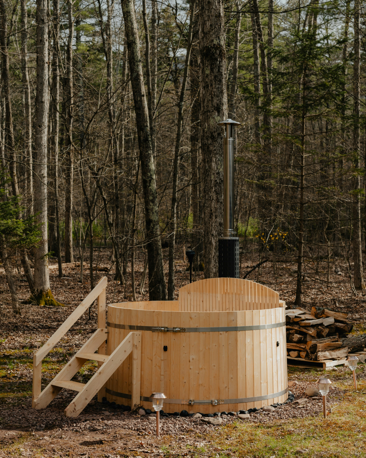 A wood-fired hot tub nestled in a quiet forest provides a luxurious escape from daily stress.