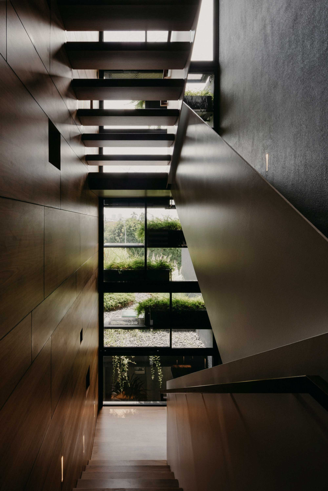 Walnut finishes in this stairwell imbue the space with a sense of warmth