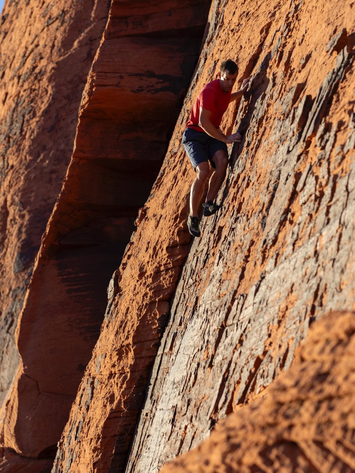 Alex Honnold, the renowned rock climber, scales a desert rock face.