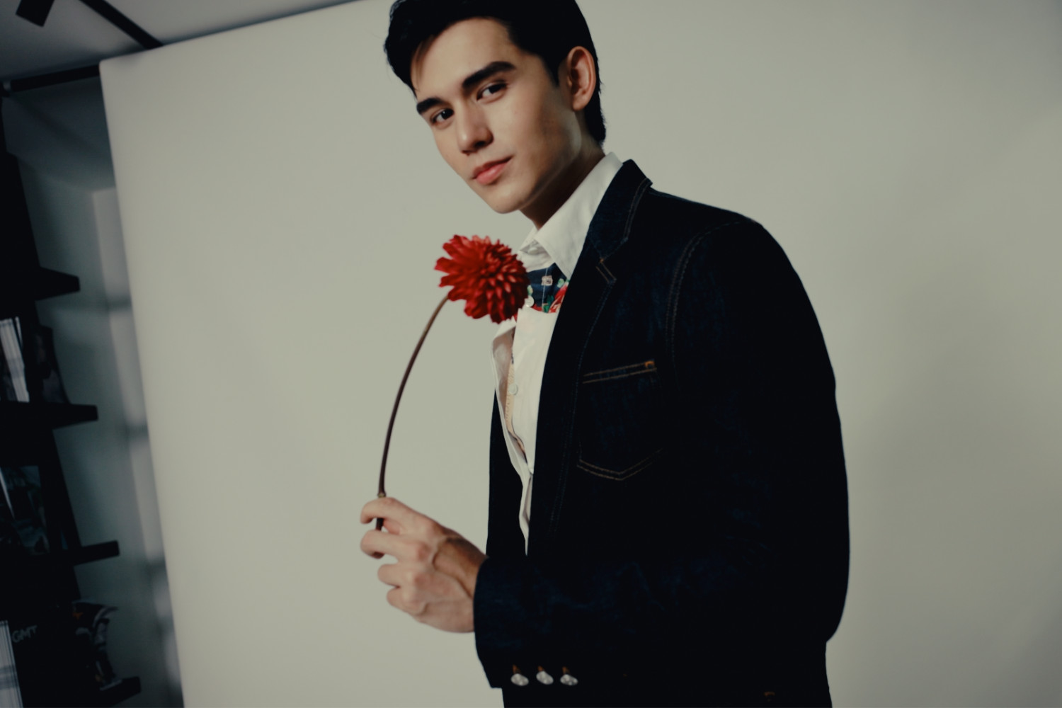 Tatler Thailand built its Most Stylish list around the theme 'Floral' Dreams. Seen: A man exudes modern elegance, blending a crisp shirt, patterned bow tie, and denim jacket, accented by a red flower.