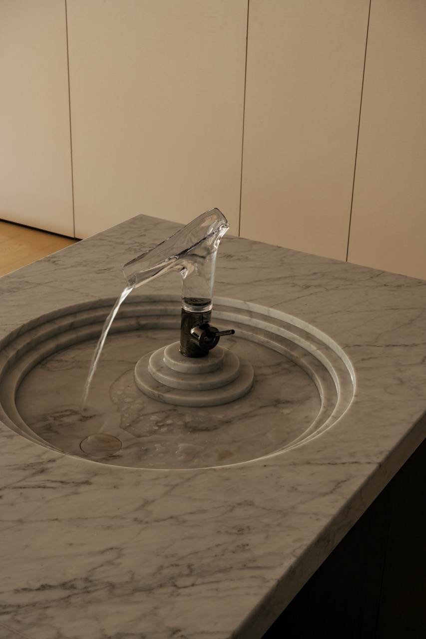 A Carrara marble basin paired with the AXOR Starck V faucet, its form adjusted to control water splash