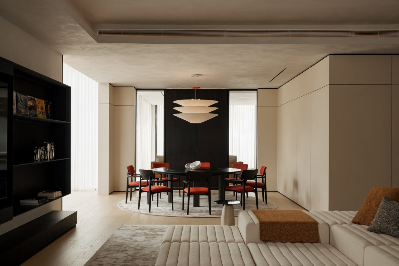 A wider view of the same dining area, opening onto a sofa and living space beyond