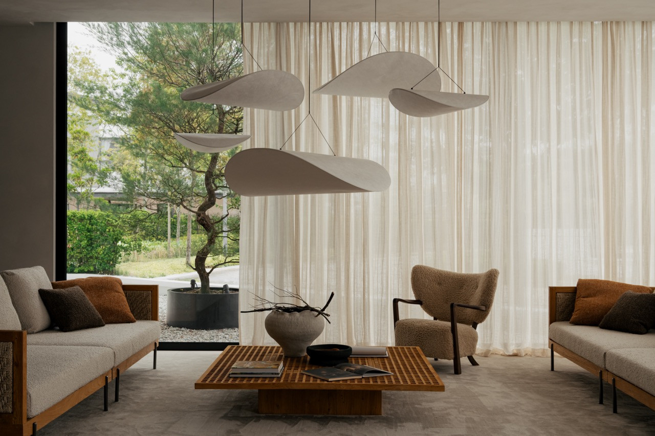The living area opens toward a planted courtyard visible through floor-to-ceiling glass.