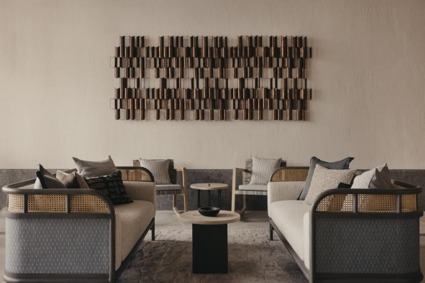 A rhythmic custom Brutalist-inspired metal wall relief by Caramel Inc anchors the other end of the lounge