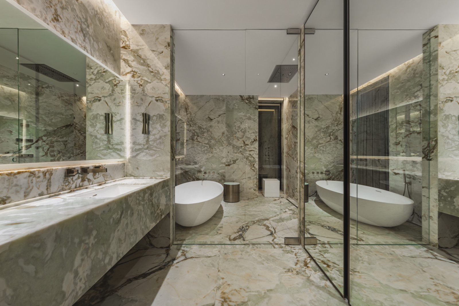 The Porsche Design Tower features a bathroom with opulent marble walls, floors, and a sleek freestanding bathtub.