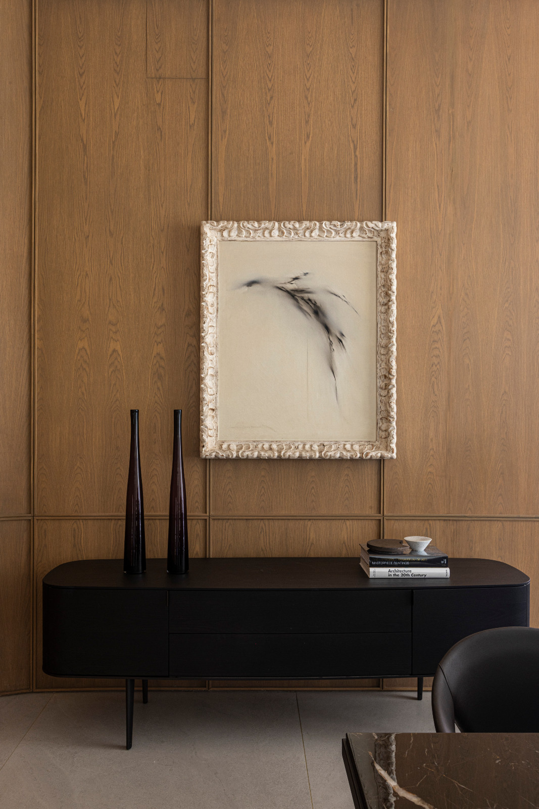 Wall cladding design continues from the living room to the dining room, in wood veneer with solid wood frames in custom colored stain, the Symphony sideboard by Poliform and an artwork by Fernando Zobel
