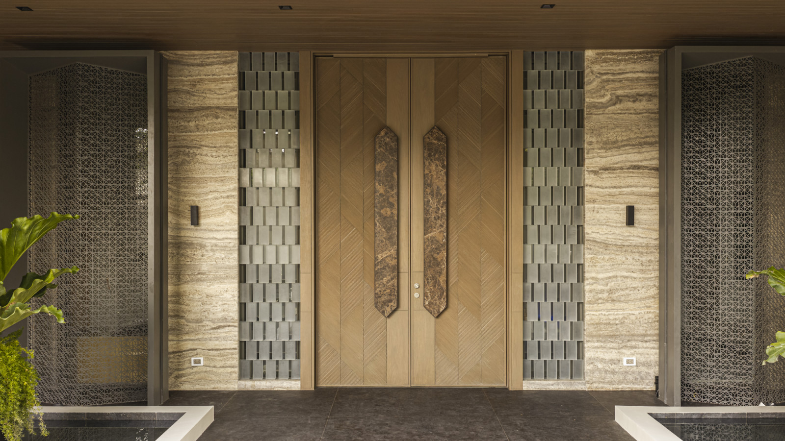 Appliqué-designed double-leaf ashwood door with custom-made Emperador brown marble handles and staggered-pattern frosted
glass-brick sidelights