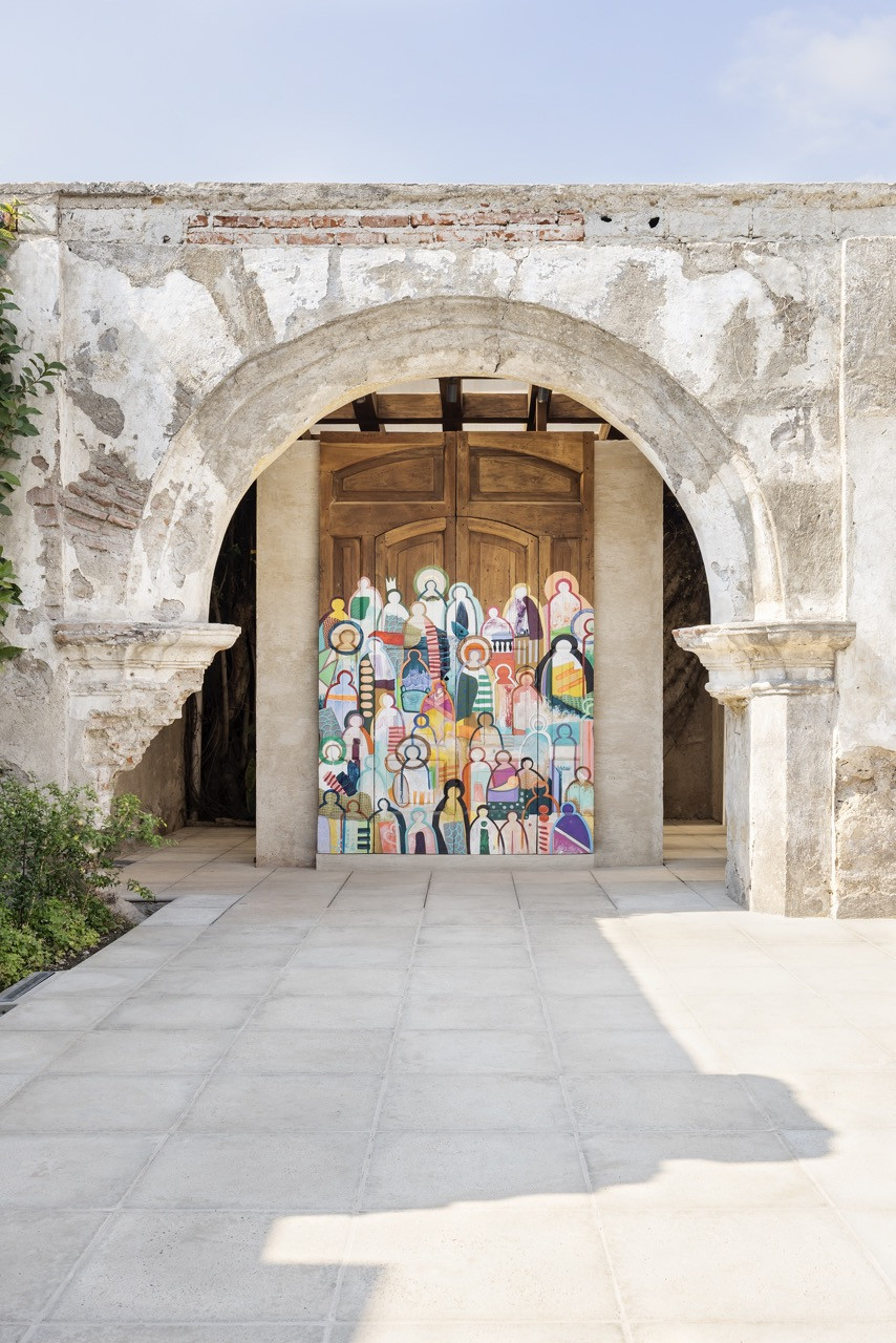 A colourful mural, painted directly onto a wooden door, sits within one of the property’s original stone archways