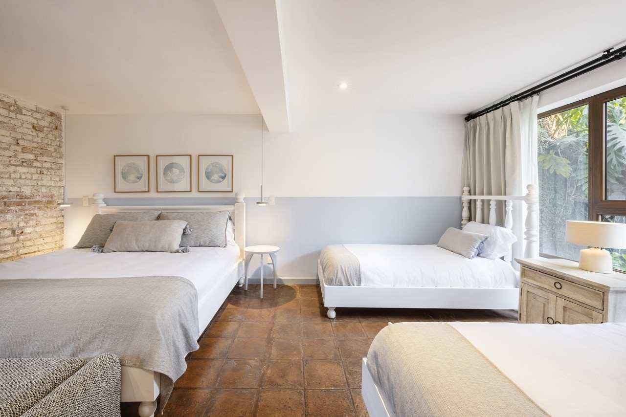 Restored terracotta flooring runs through this bedroom, paired with a pale blue palette drawn from the Tuscan countryside
