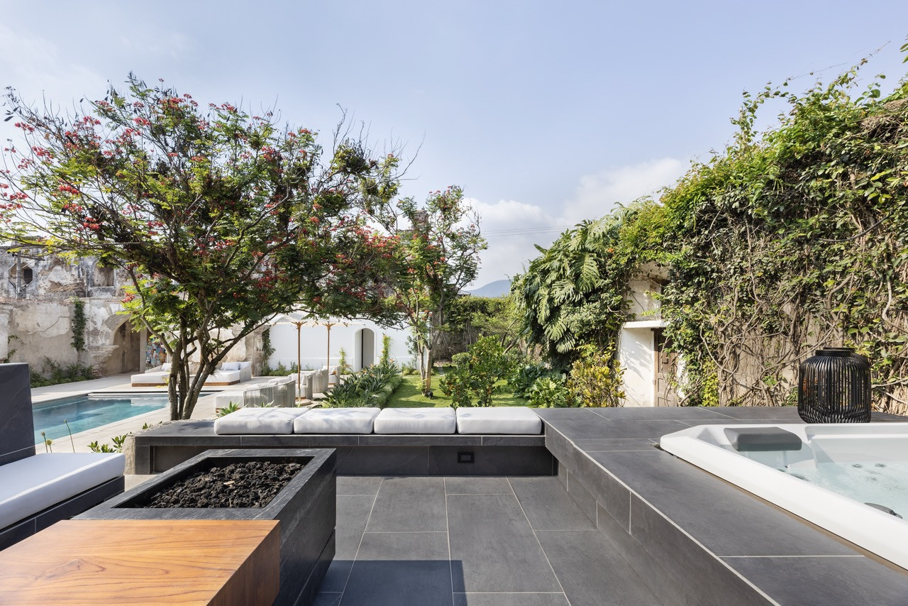 The jacuzzi and firepit terrace look out over a garden planted along the property’s perimeter