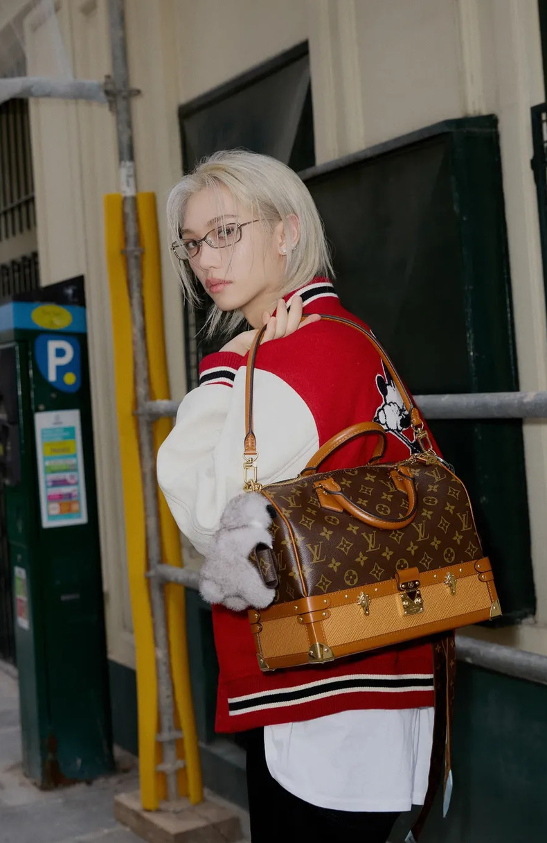 Felix from Stray Kids styles a Louis Vuitton Speedy Bandoulière bag with a varsity jacket.
