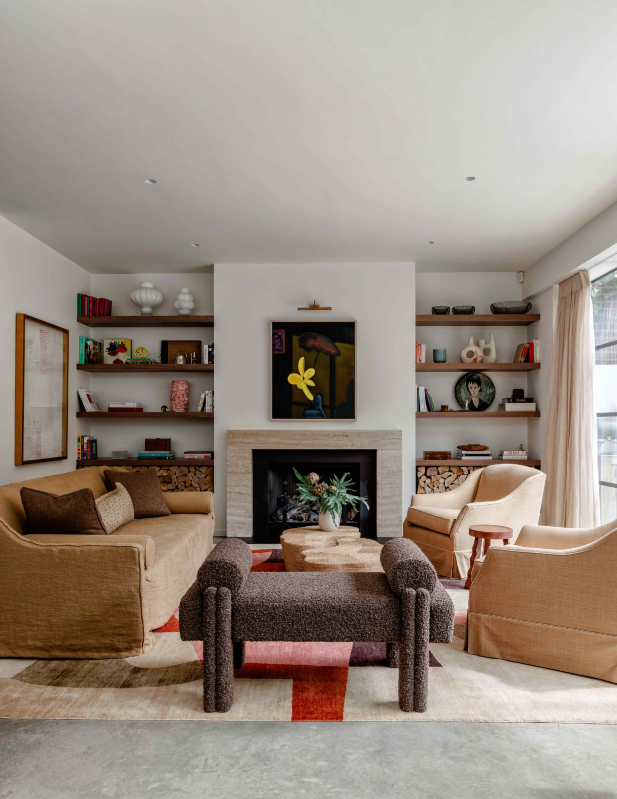 Linen and bouclé upholstery bring softness and tactility to the living room with a veined marble fireplace