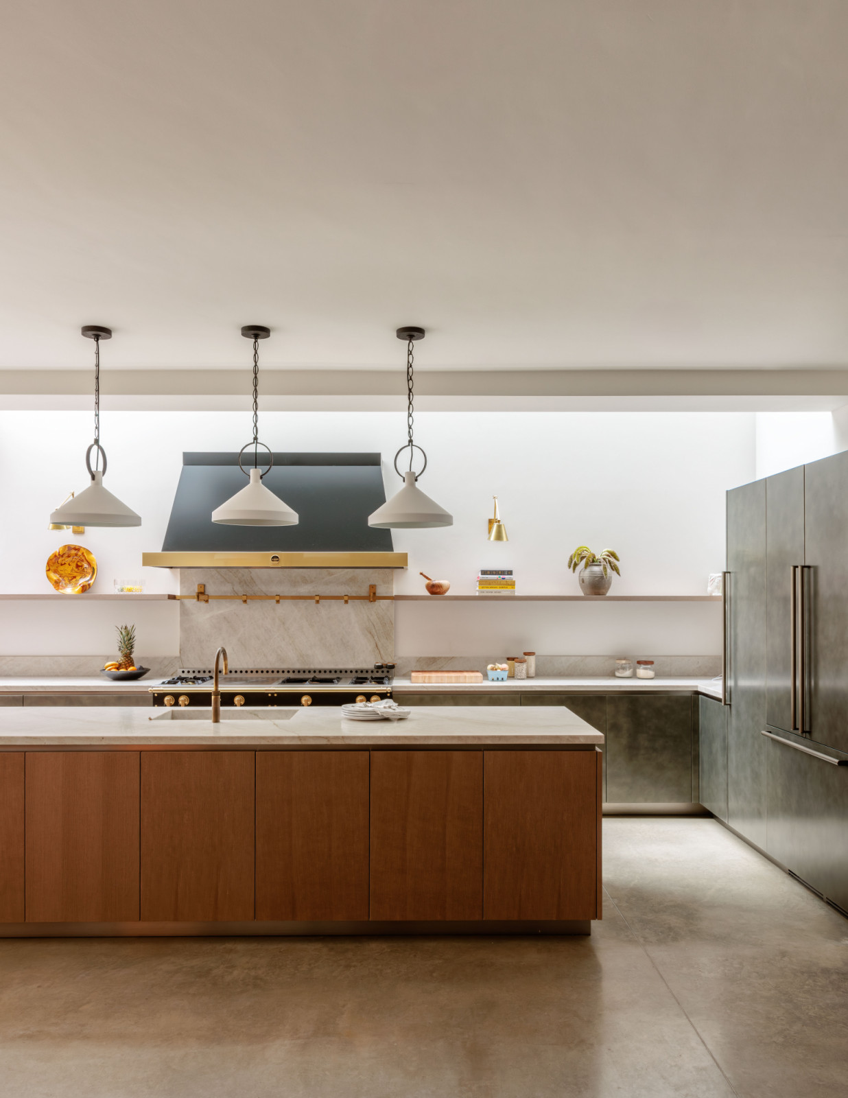 A timber island and stainless steel cabinetry in the kitchen