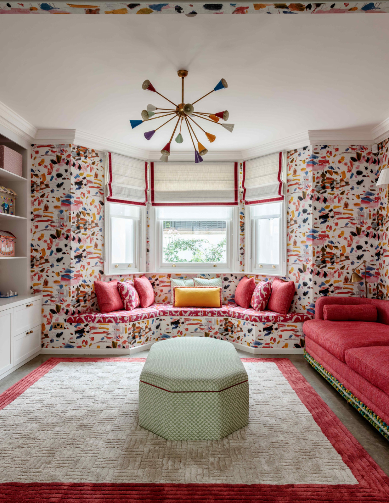 The whimsical playroom with fuchsia pink furnishings that compliment the vibrant wallpaper