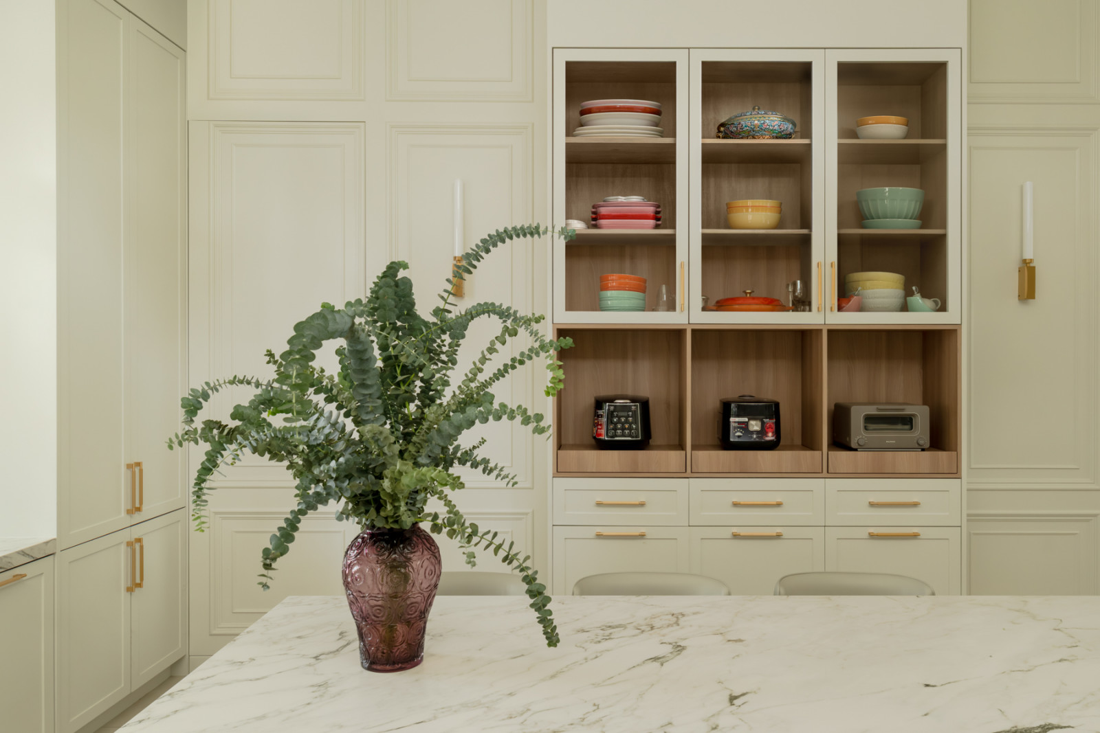 Open shelving in the kitchen displays crockery and small appliances in a range of colours