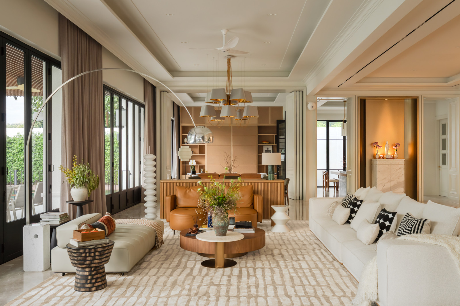 The living area’s tan leather seating faces a fluted timber bar, glimpsed through to the dining room beyond
