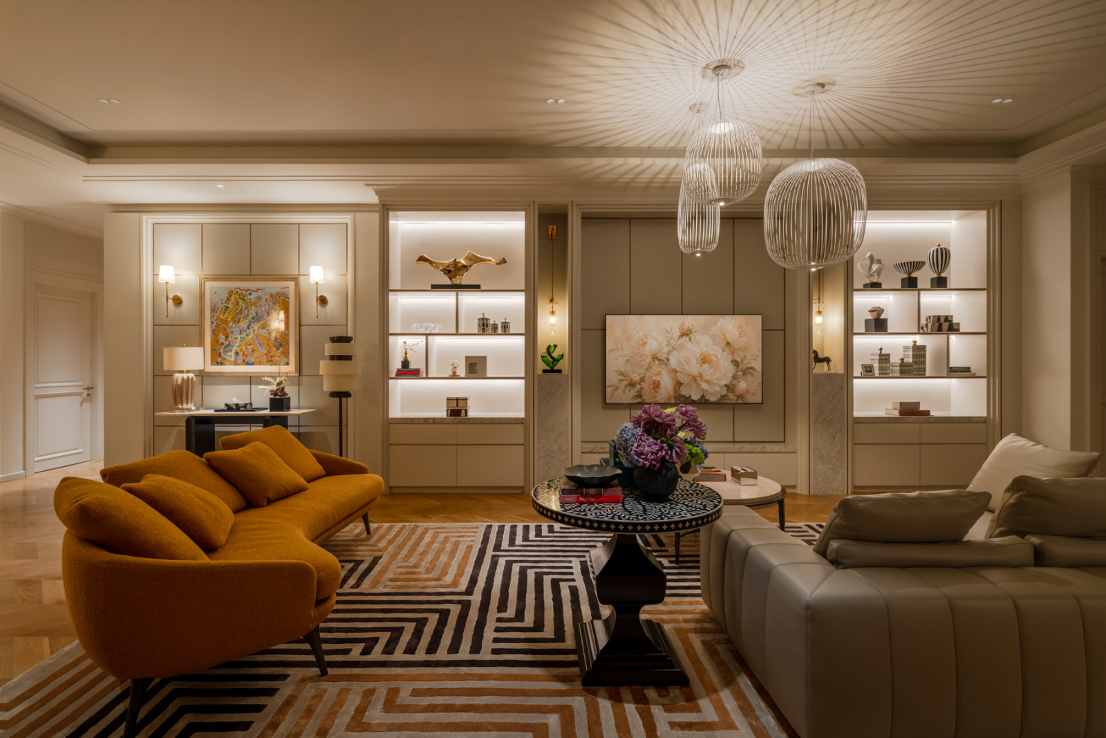 Burnt-orange and grey seating flank a black-and-white geometric rug, with backlit shelving displaying ceramics and sculpture behind