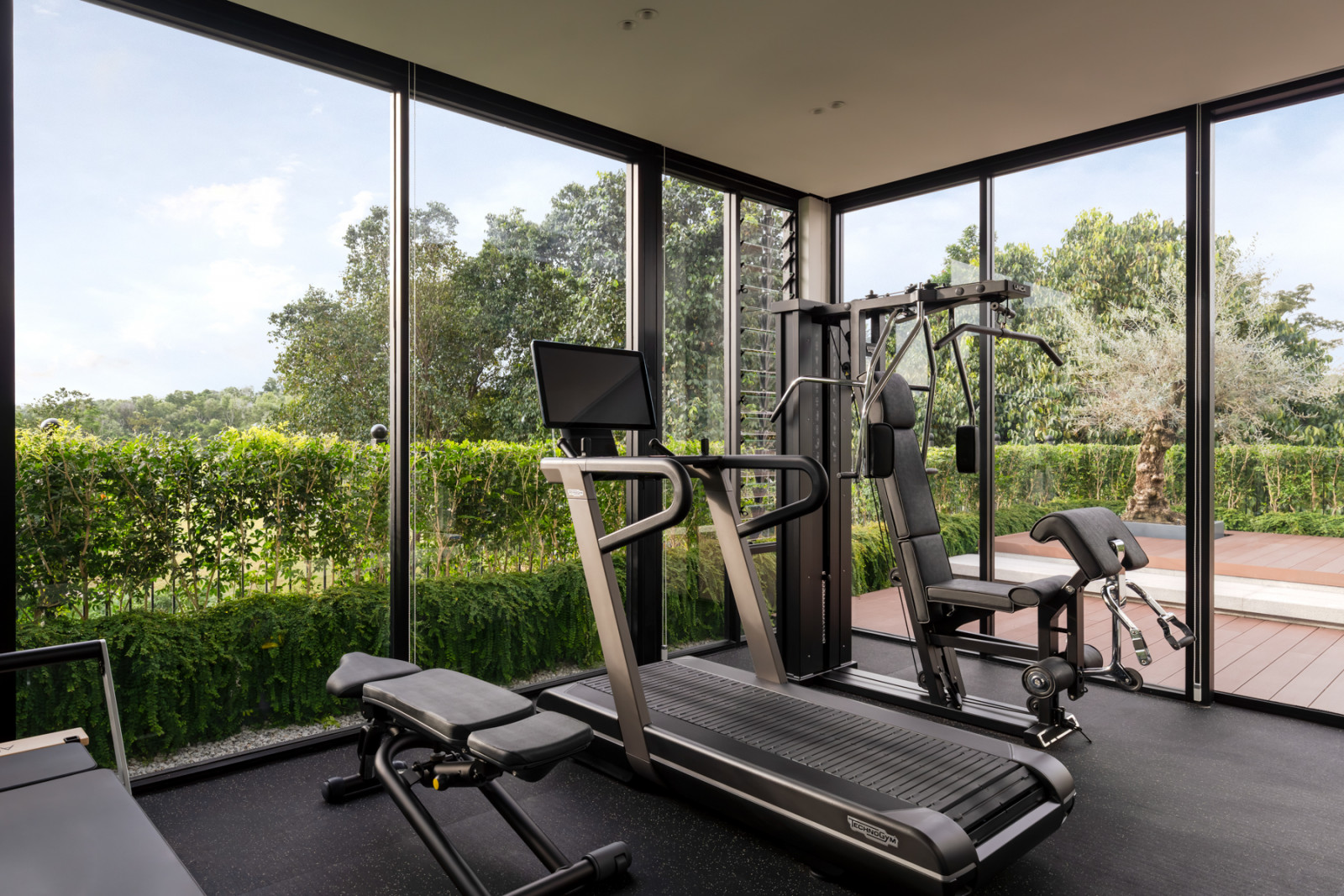 The top-floor gym is fitted with Technogym equipment and floor-to-ceiling glazing overlooking the garden and rooftop terrace