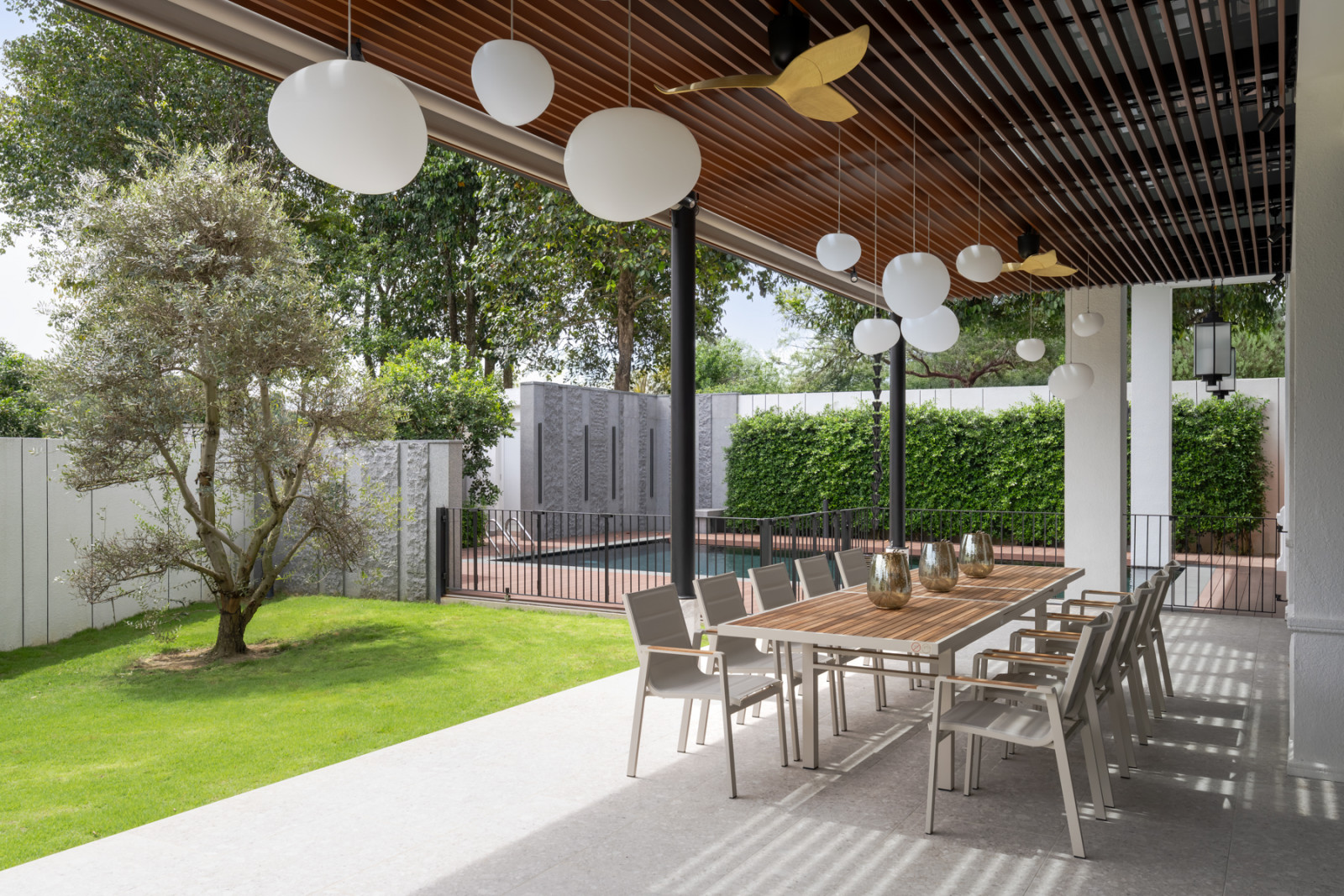 The covered dining terrace looks out over the garden, olive tree and swimming pool below