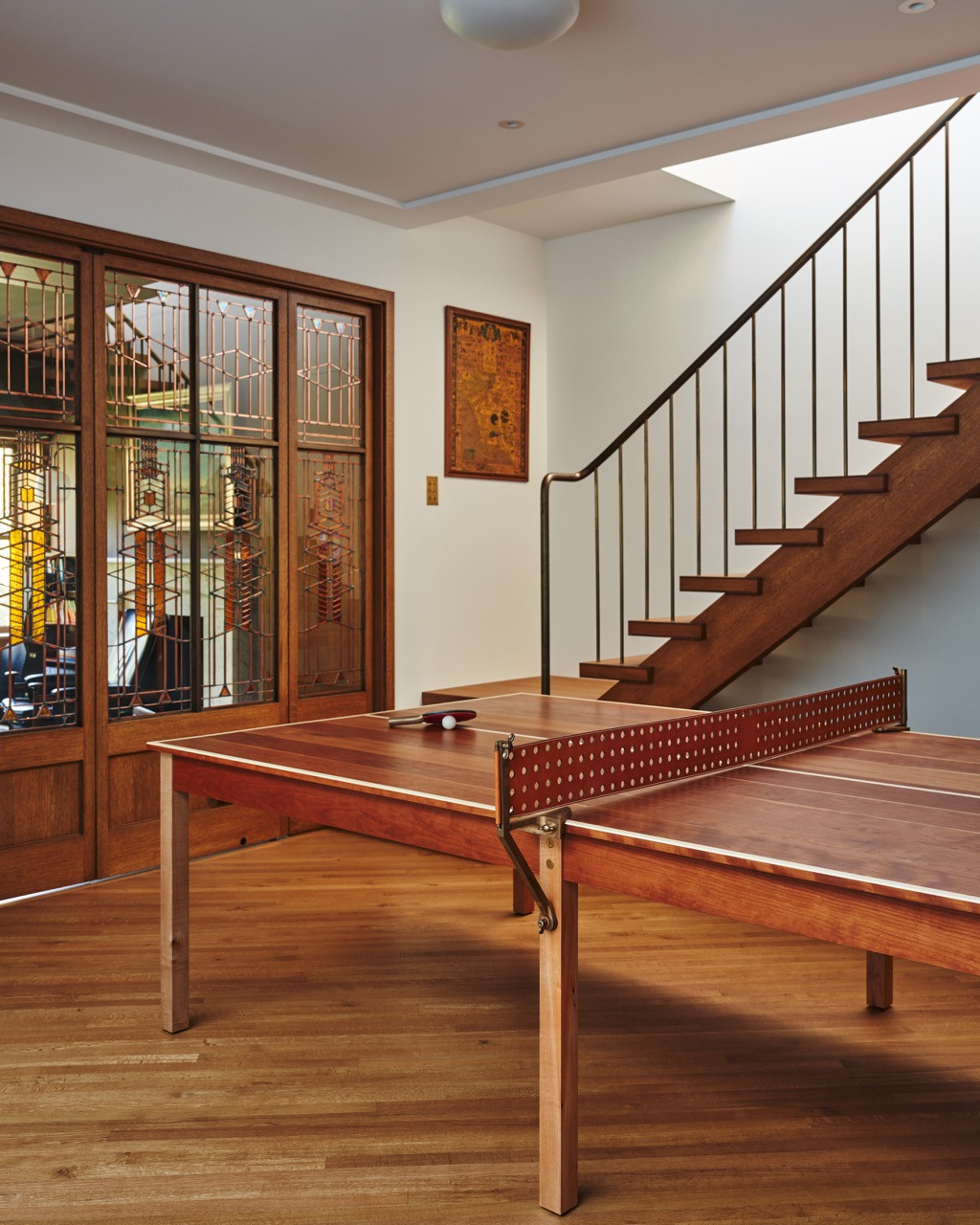The ping-pong table again, this time showing the full run of leaded-glass doors and the stairway beyond