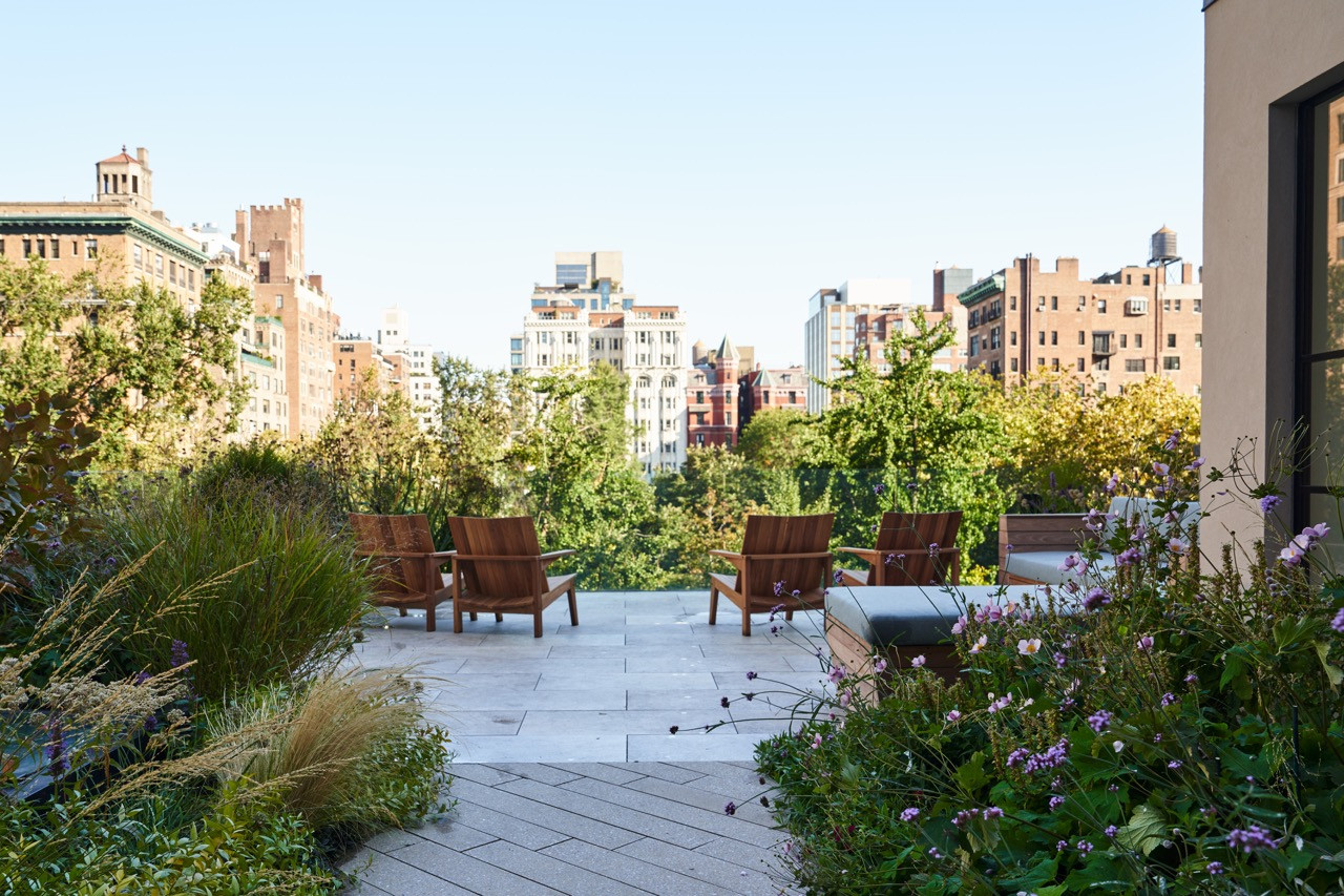 Another view of the rooftop terrace, with its lounge chairs and plantings set against the Manhattan skyline