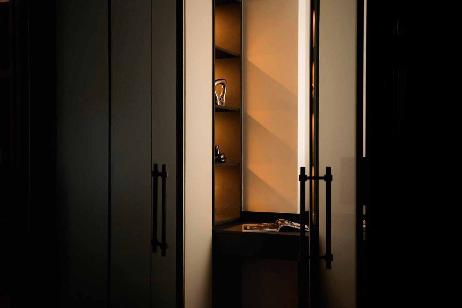 LA Design Studio devices a niche that integrates shelving and a fold-out surface in this snug yet stylish East Coast apartment