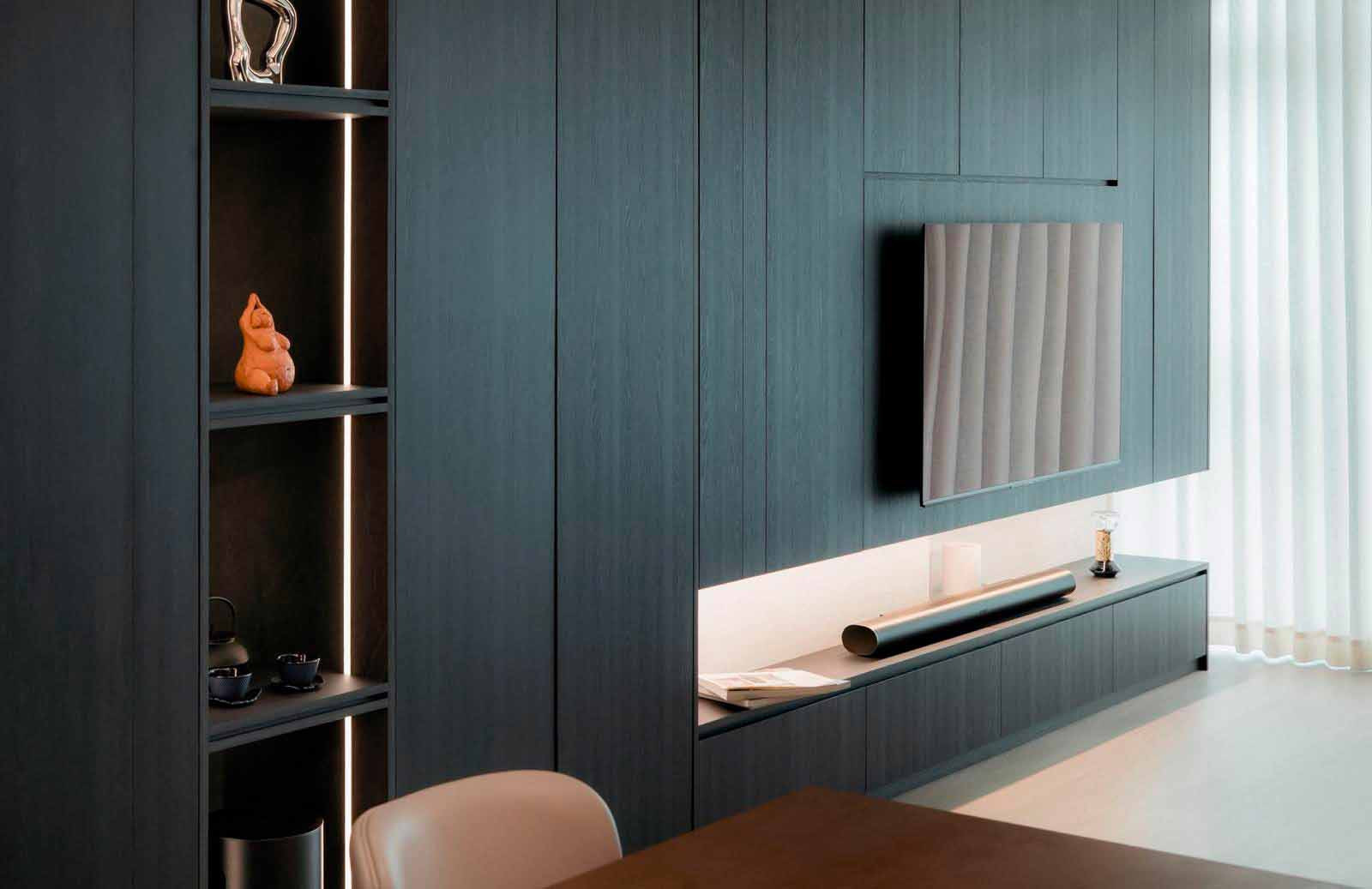 The full-height dark cabinetry features open shelving and lighting