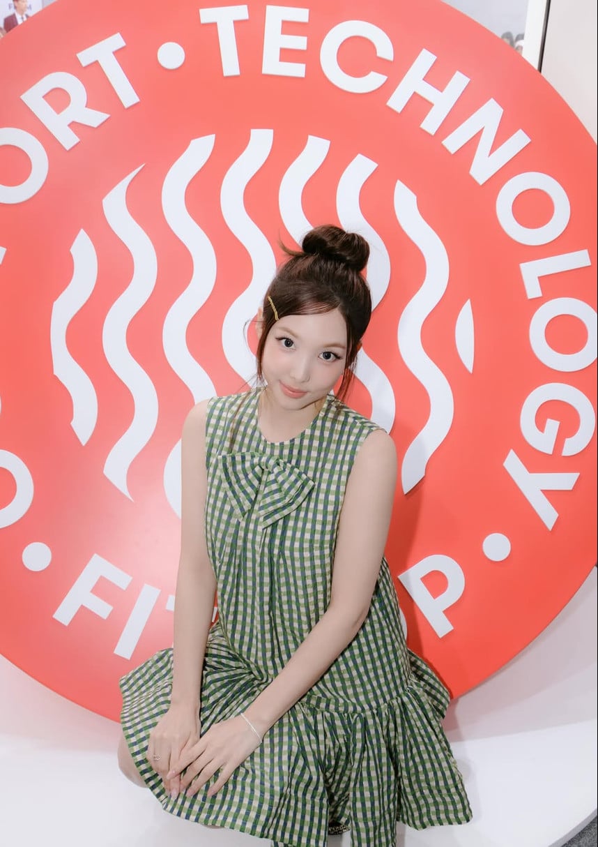 TWICE member Nayeon poses in a green checkered dress.