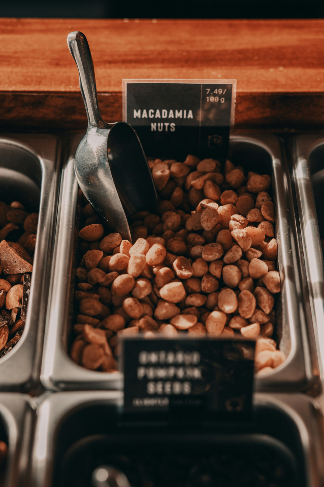 Macadamia nuts are available in a bulk dispenser, priced at 7.49 per 100g.
