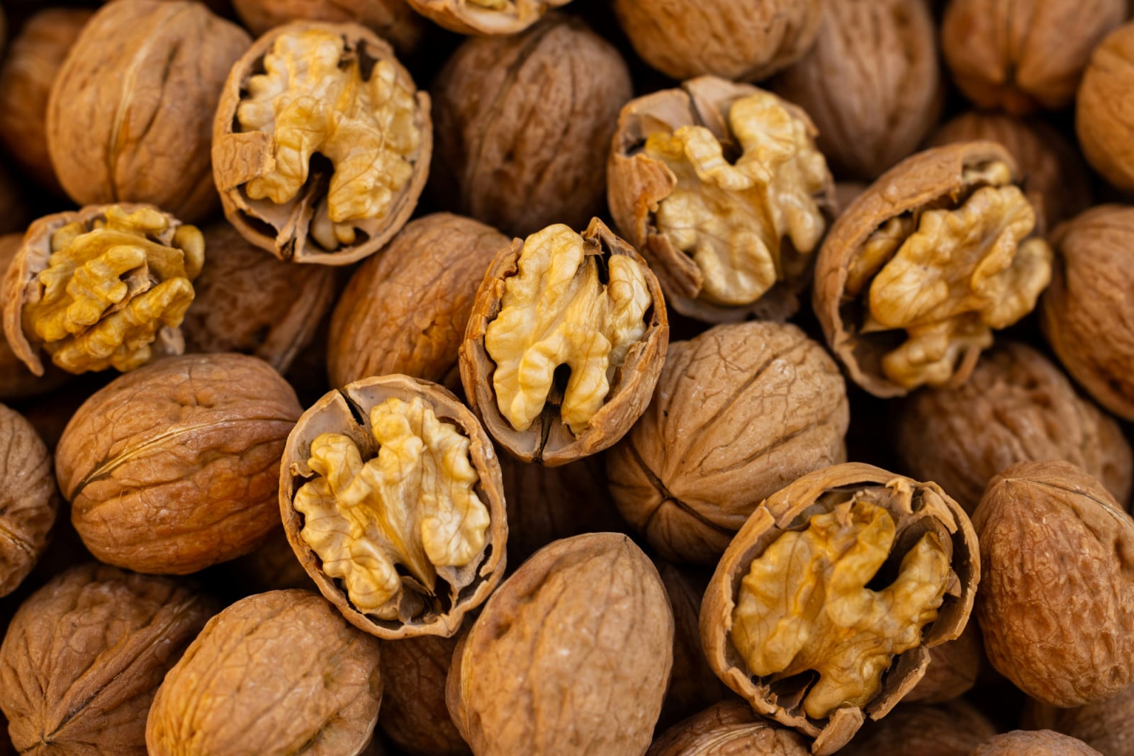 Walnuts are displayed, some whole and others cracked open to reveal their kernels.