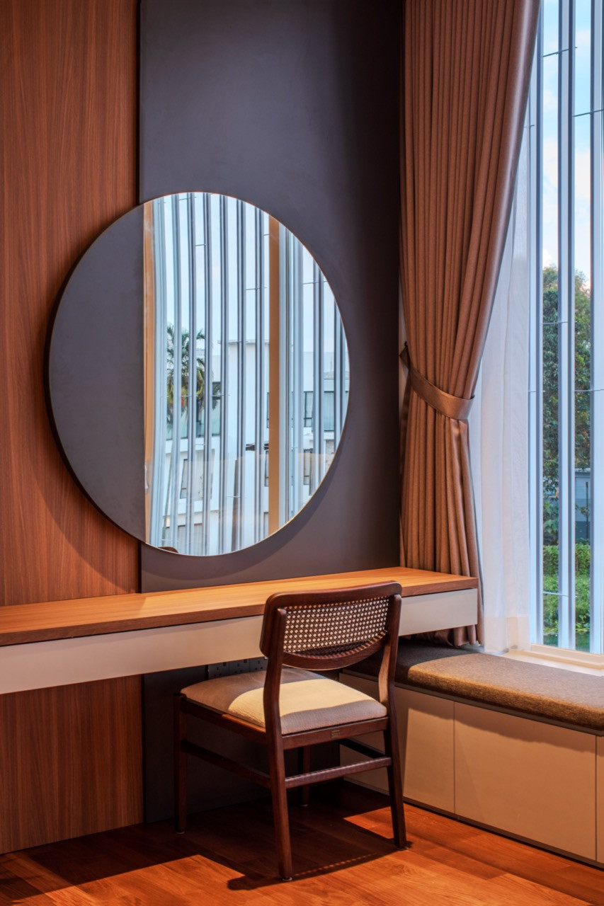 A dressing nook off one of the bedrooms, with a round mirror set against timber panelling