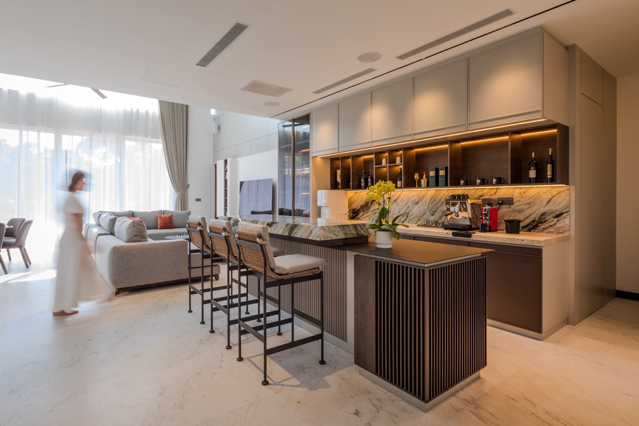 The kitchen and bar area, finished in green quartz and opening onto the main living space