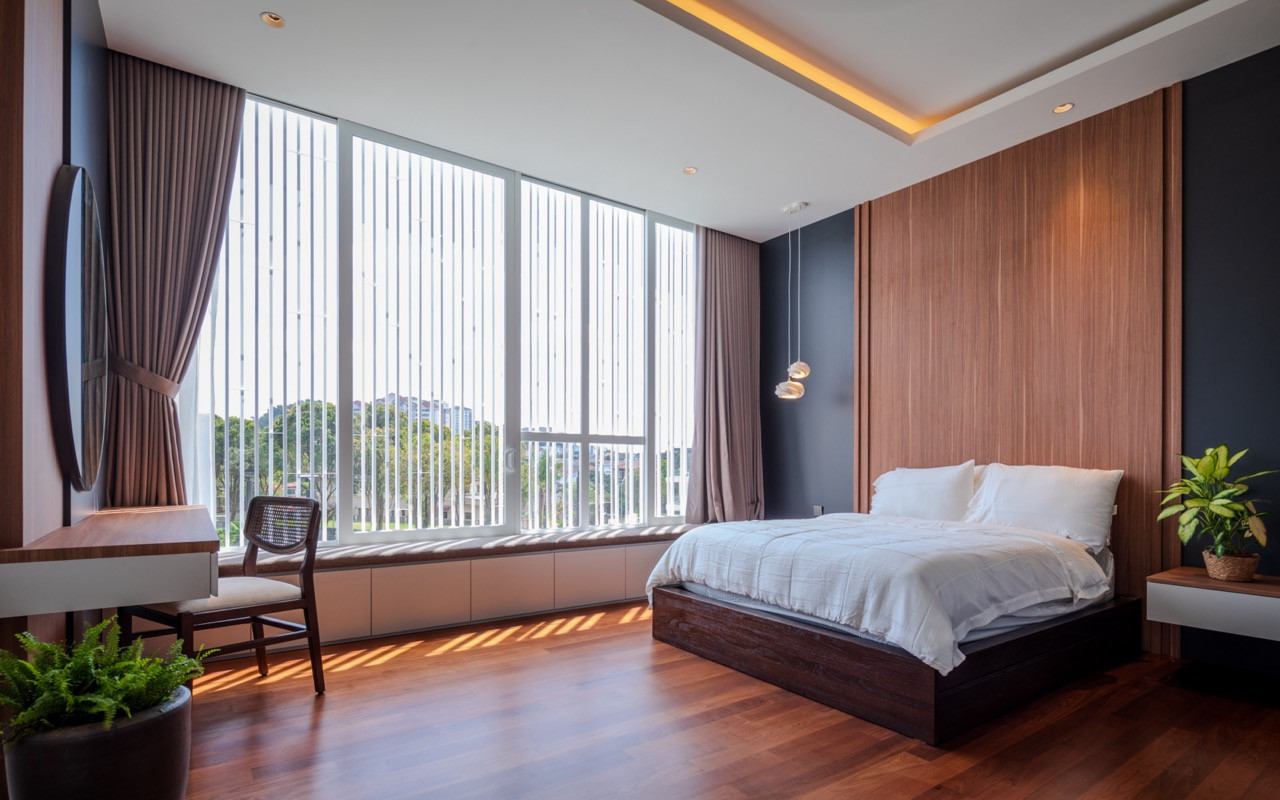 A bedroom finished in warm timber, offset against the white architecture elsewhere in the house