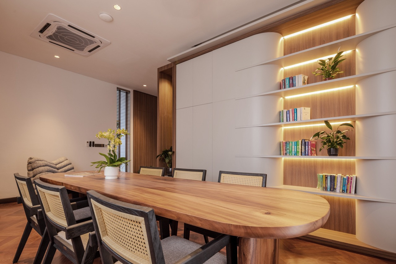 The study, with a long timber table and a bookshelf built into the wall