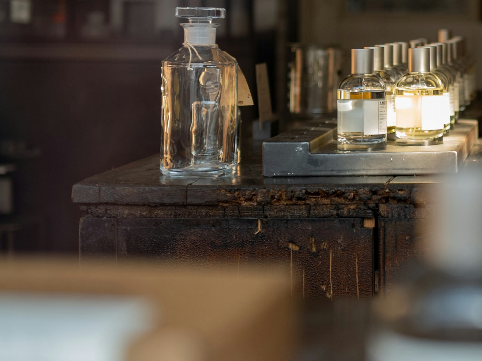 Fragrance decanters and a line of perfume bottles, including an "Ambre" scent, showcase the artistry of perfumery.