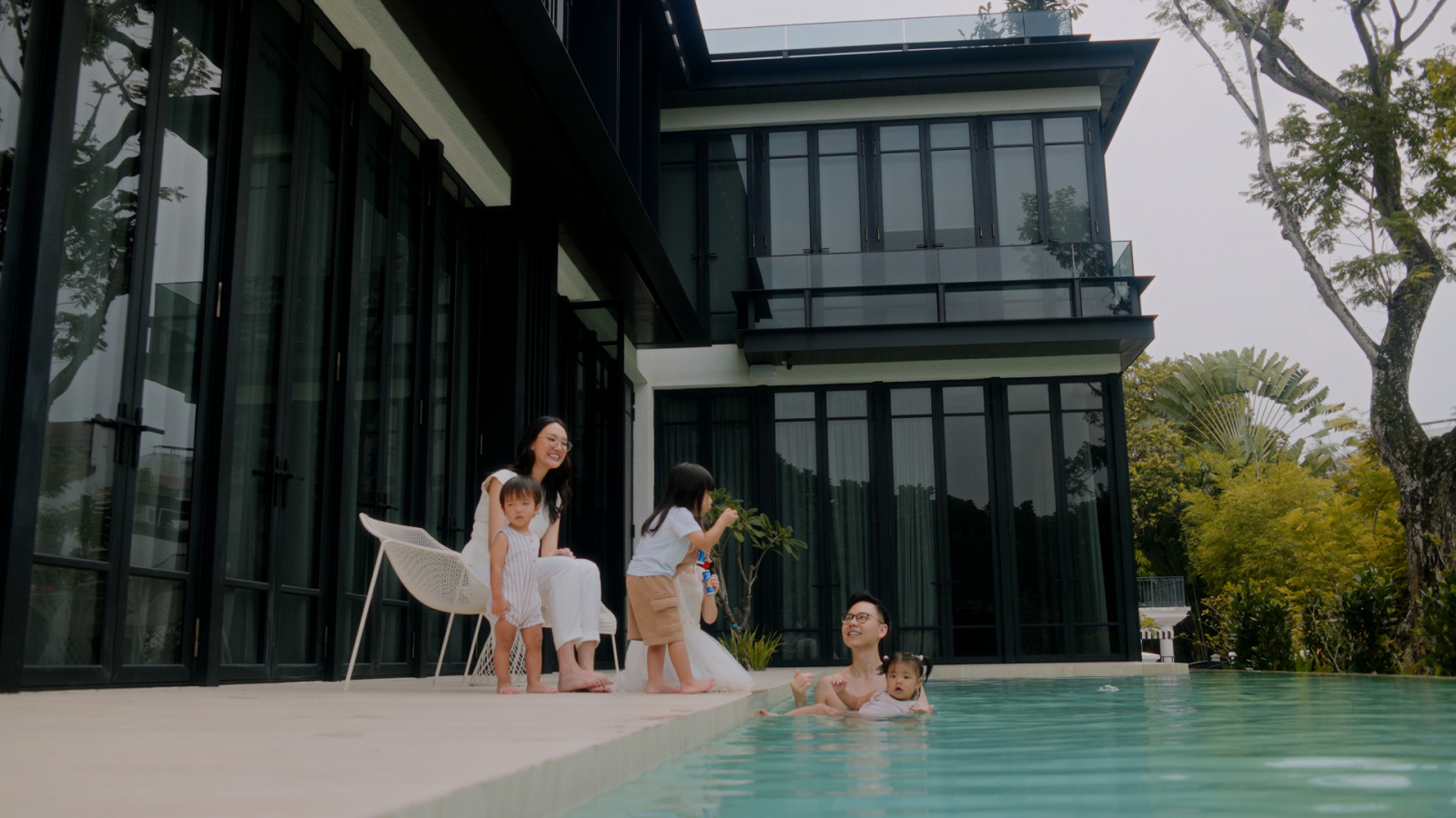 With breakfast kept warm by V-ZUG, the family is free to linger by the pool, the bungalow rising behind them