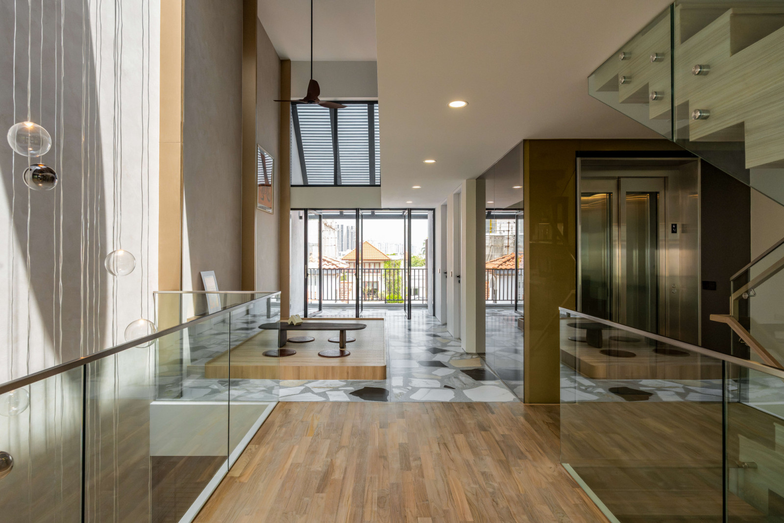 The open-riser staircase, transparent balustrades and framed sightlines reinforce the visual connections between floors