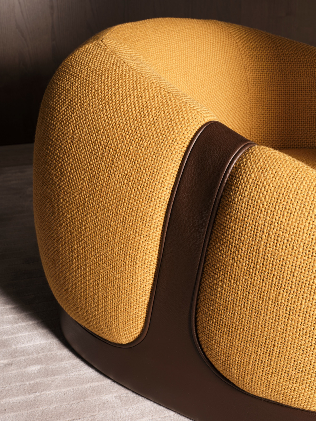 Leather defines the lower shell and belt, with upholstery that envelops the body