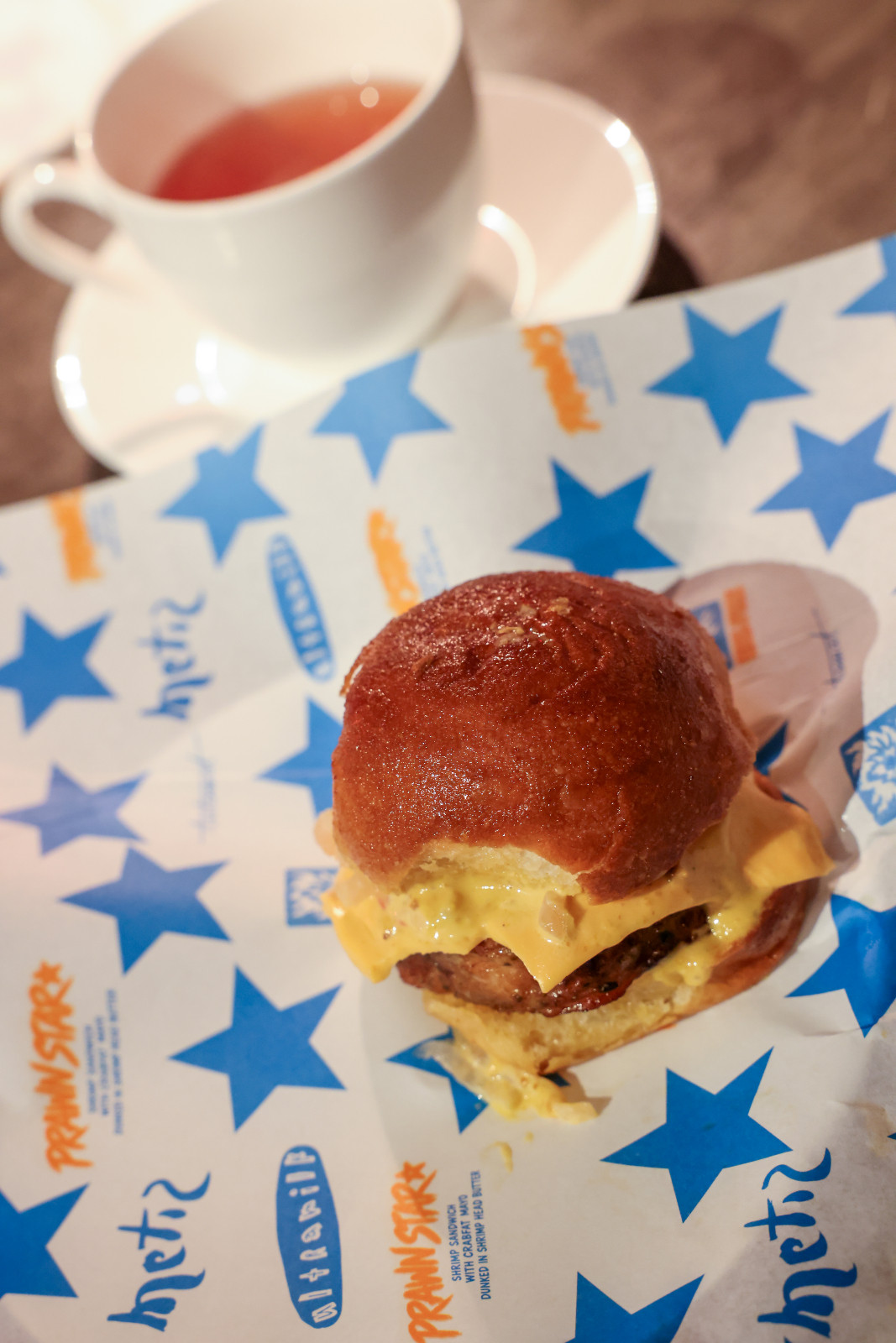 Metiz’s chefs Stephan Duhesme and Arlo Gregorio developed a playful burger titled ‘The Prawnstar’, with a fried prawn and pork patty, crab fat mayo, atsara, American cheese and homemade prawn-butter-soaked pandesal, wrapped in their own uniquely branded paper | Off Menu 2026