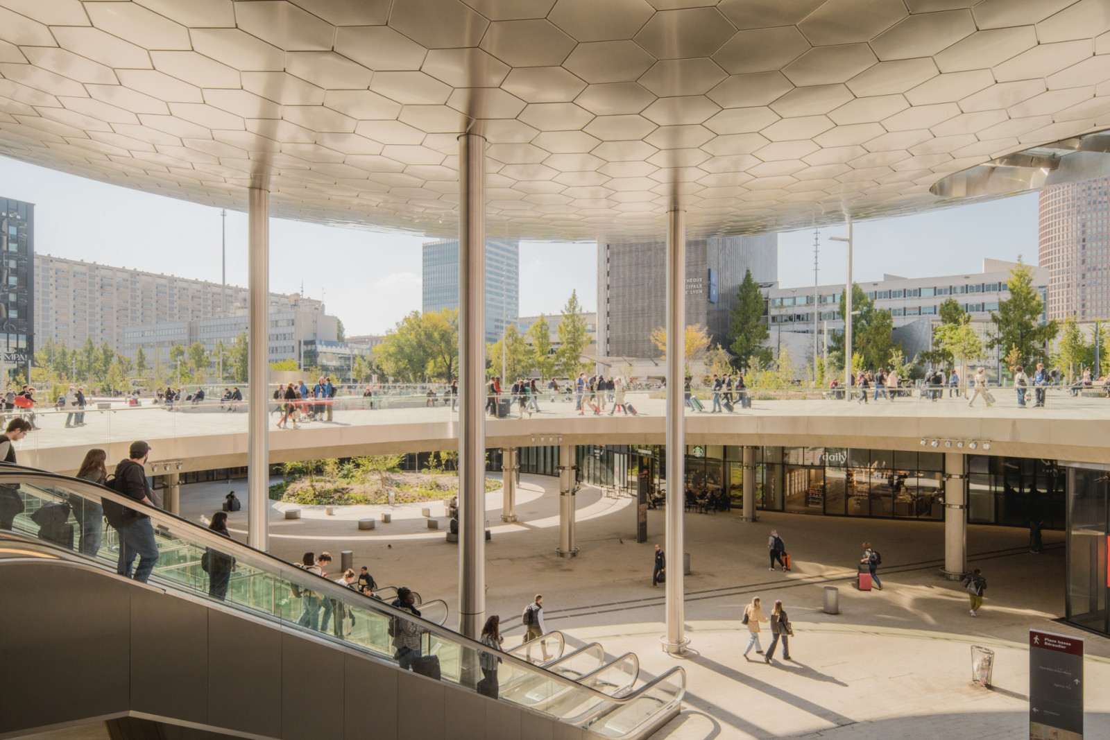 Stainless steel columns hold up a canopy of hexagonal metal panels over the lower level of Place Charles Béraudier, the two-level square outside Lyon Part-Dieu Station (Photo: Romuald Nicolas)