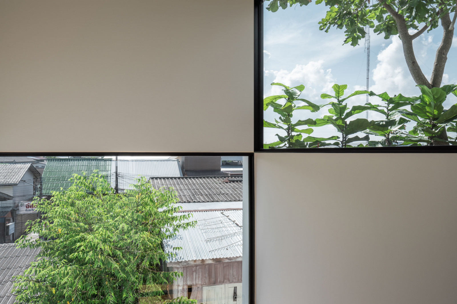มุมมองจากหน้าต่างที่ถูกตีกรอบ (Framed view) อย่างตั้งใจ ให้เห็นต้นไม้และหลังคาบ้านข้างเคียง เสมือนเป็นงานศิลปะที่เชื่อมโยงกับบริบท (ภาพ: Chalermwat Wongchompoo | Sofography)