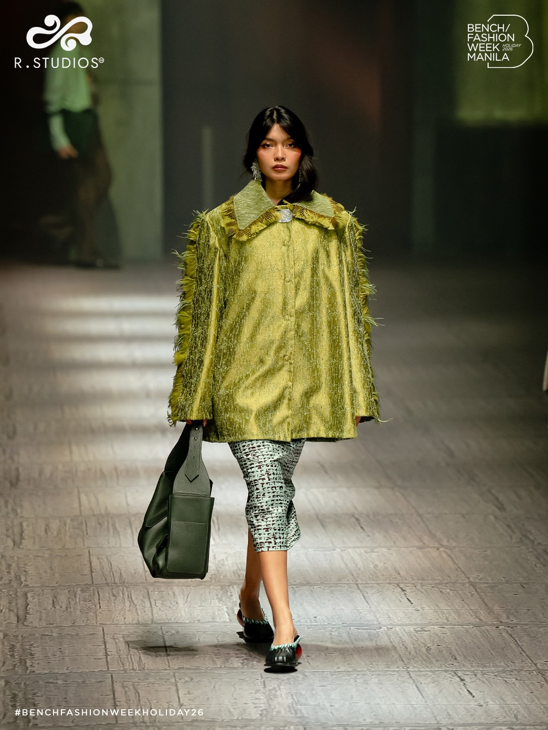 R. Studios unveils a distinctive green coat with feather embellishments and a patterned skirt from its Holiday 2026 collection