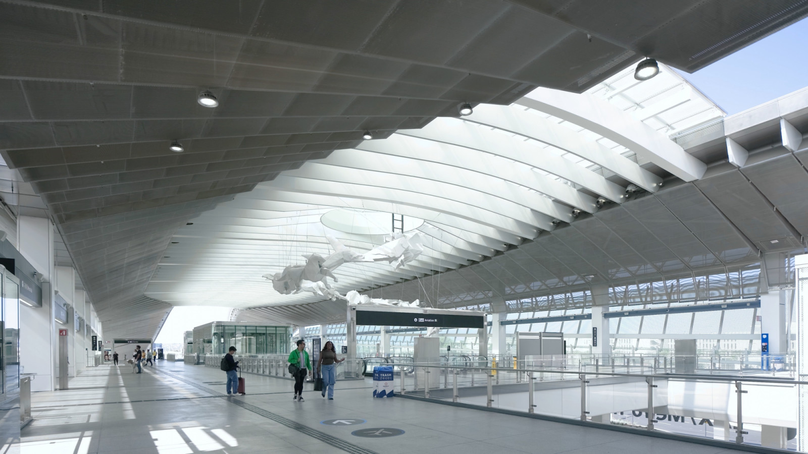 A white sculptural installation hangs beneath the ribbed canopy of the upper concourse at the LAX/Metro Transit Center in Los Angeles (Photo: Jason O’Rear)