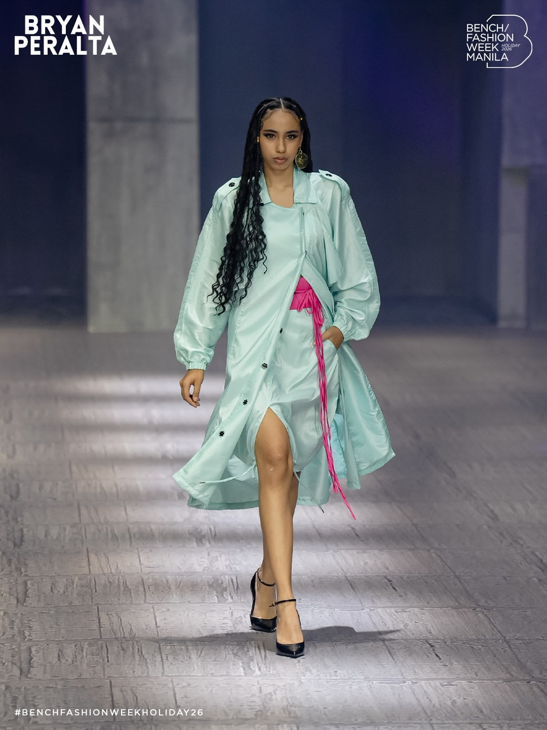 A model presents a Bryan Peralta light blue trench dress with pink accents for Bench Fashion Week Manila Holiday 2026