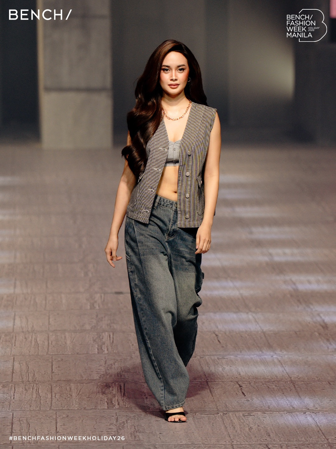 A model showcases a striped vest and wide-leg jeans from Bench's Holiday 2026 collection at Bench Fashion Week Manila