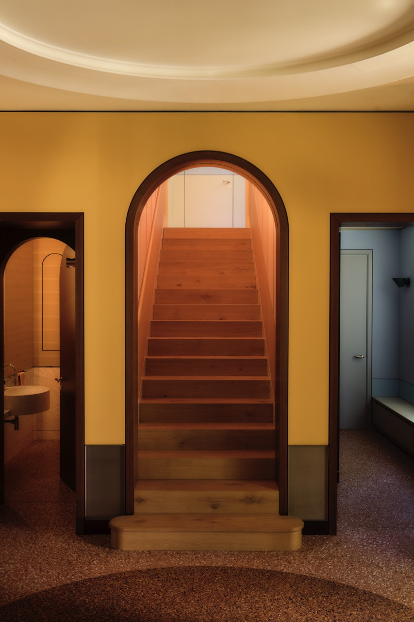 Three arched doorways open off the yellow hall, one leading to the tunnel staircase
